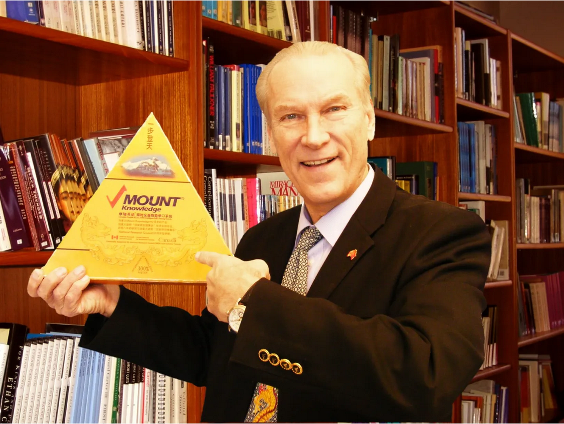 Prof. Erwin Sniedzins holding the Mount Knowledge pyramid award